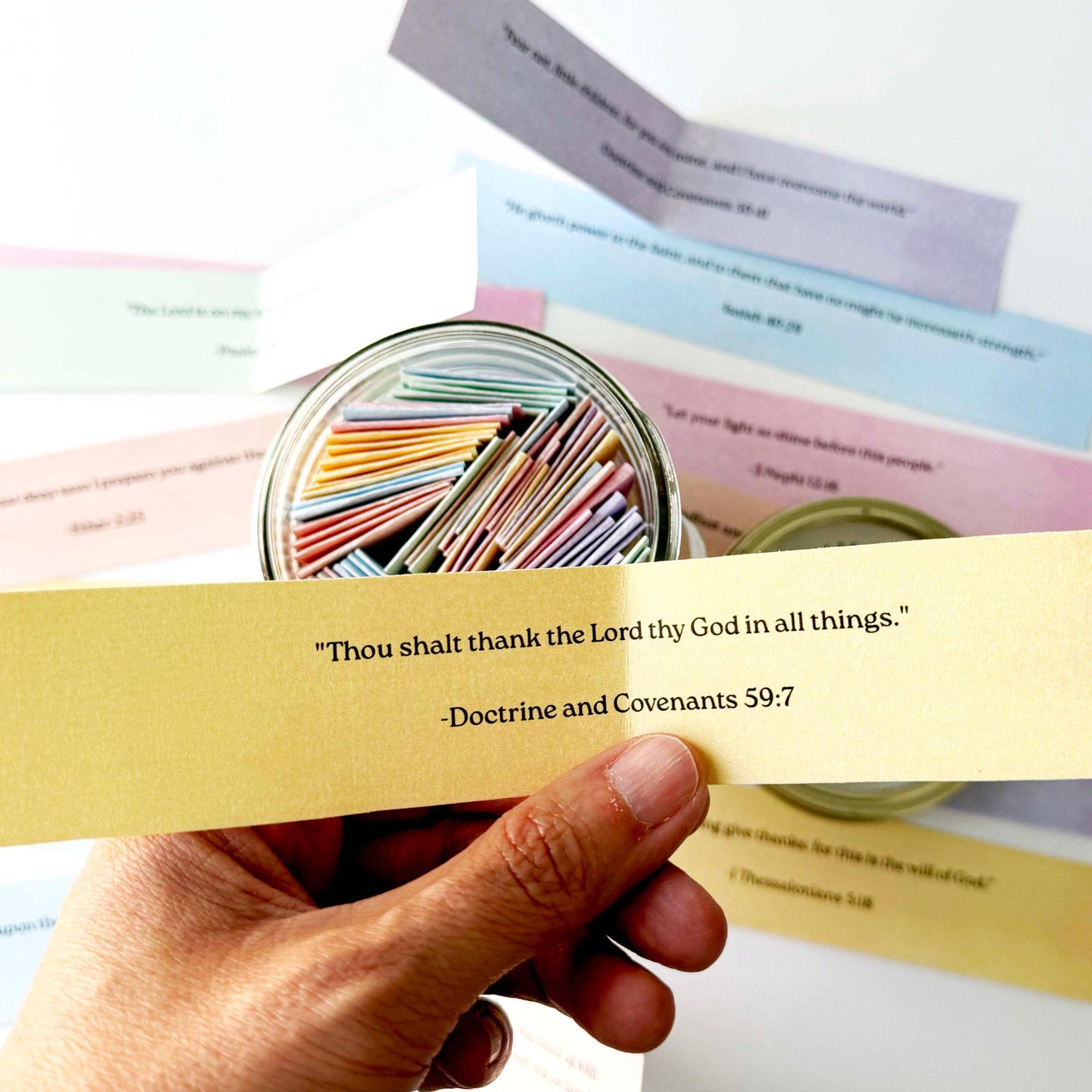 Hand holding a yellow Read Me When scripture card beside colorful faith based emotion prompts and open scripture jar
